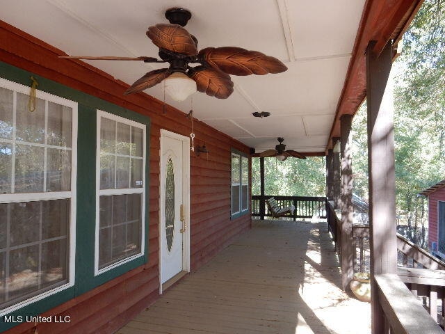 wooden terrace featuring a porch and ceiling fan