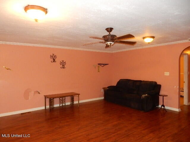 living room featuring crown molding, dark hardwood / wood-style floors, and ceiling fan