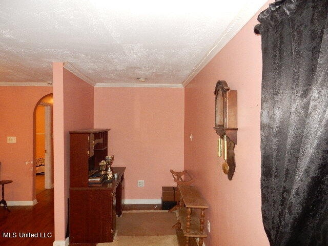 hall featuring ornamental molding and a textured ceiling