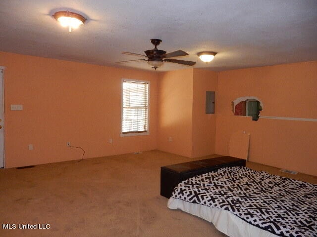 carpeted bedroom featuring ceiling fan and electric panel