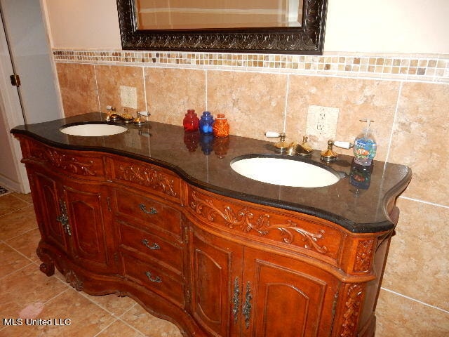 bathroom with vanity, decorative backsplash, and tile walls