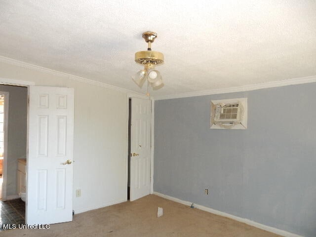 carpeted spare room with a textured ceiling, ceiling fan, lofted ceiling, crown molding, and a wall mounted AC