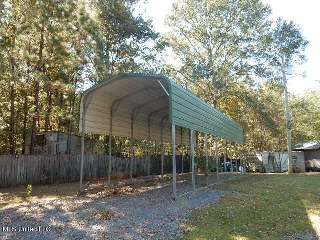 view of parking featuring a lawn and a carport