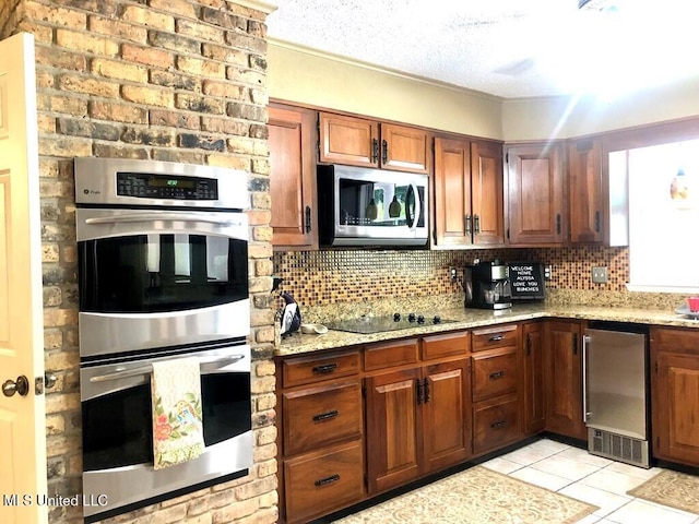 kitchen featuring light tile patterned floors, tasteful backsplash, light stone countertops, and stainless steel appliances