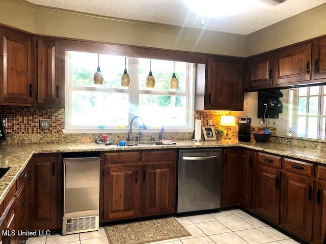 kitchen featuring backsplash, light tile patterned flooring, a sink, and dishwasher