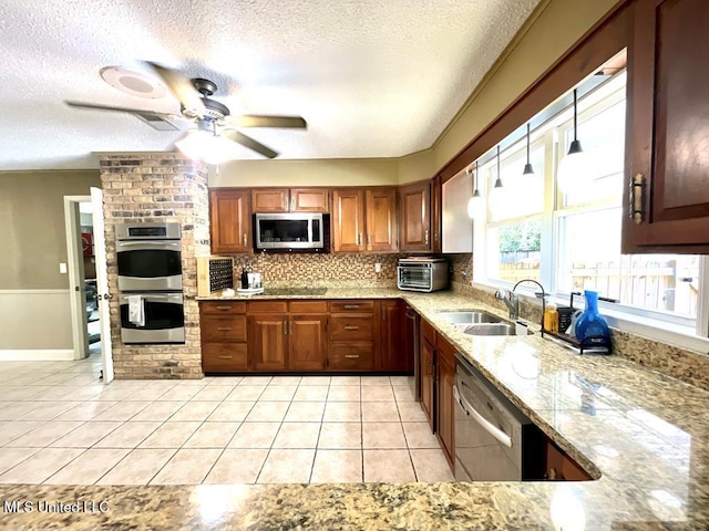 kitchen with stainless steel appliances, a textured ceiling, a sink, and light tile patterned floors
