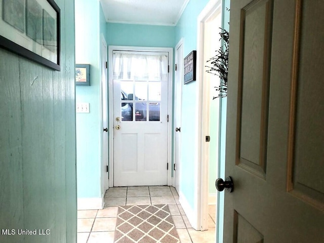 doorway to outside with baseboards and light tile patterned flooring