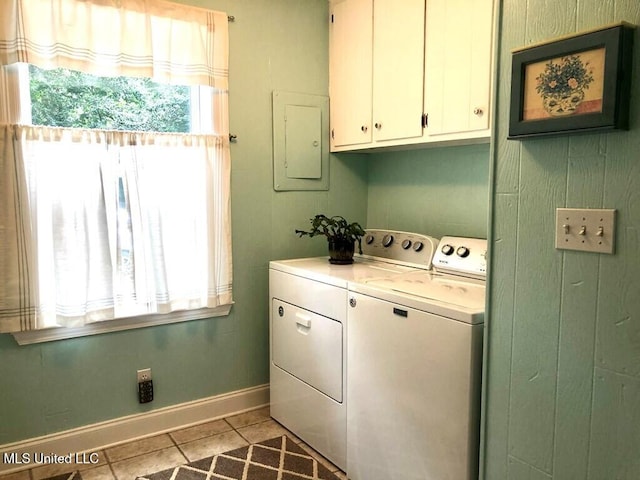 washroom featuring washer and dryer, baseboards, electric panel, cabinet space, and light tile patterned floors