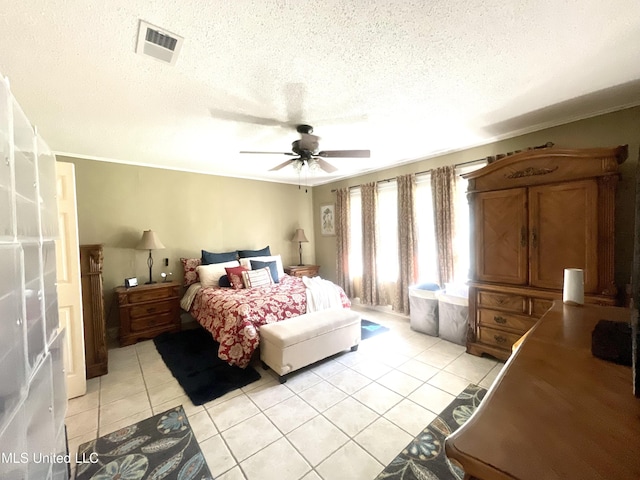bedroom with a textured ceiling, a ceiling fan, light tile patterned flooring, and visible vents