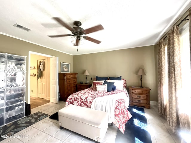 tiled bedroom featuring crown molding, a textured ceiling, ceiling fan, and visible vents
