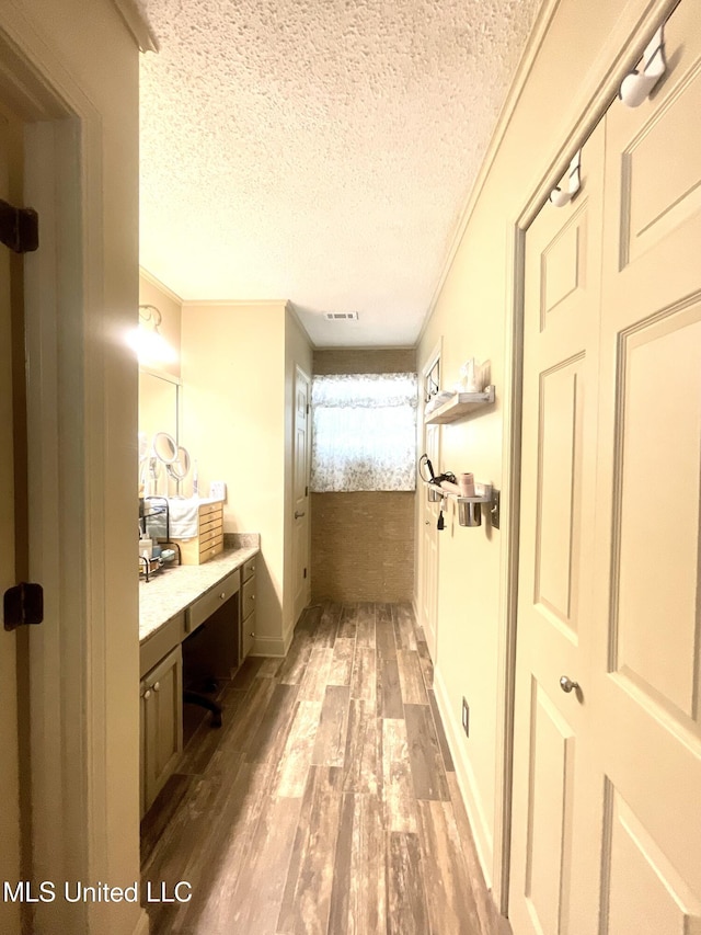 bathroom with visible vents, baseboards, a textured ceiling, and wood finished floors