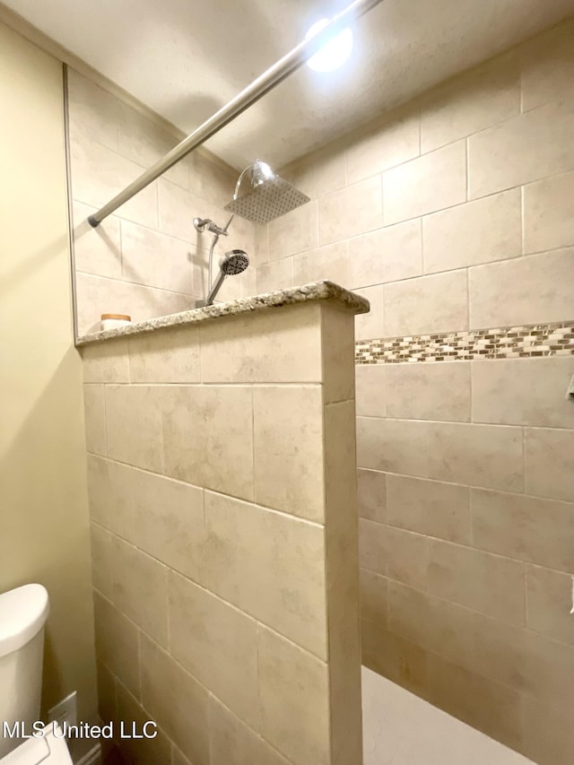 full bathroom with toilet and tiled shower