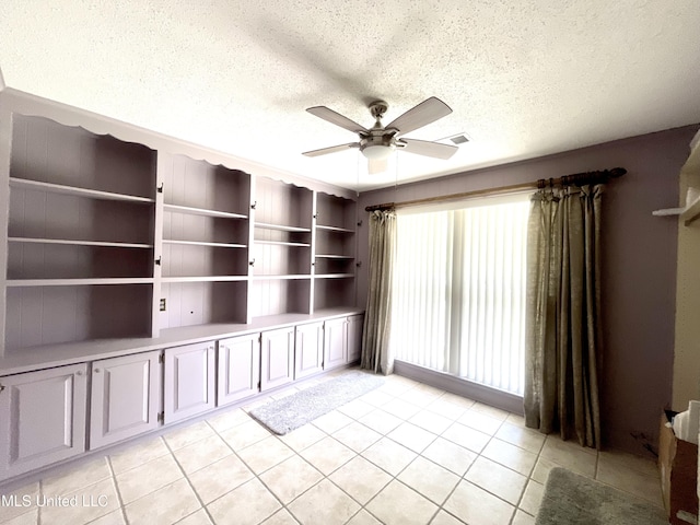 spare room with visible vents, a textured ceiling, ceiling fan, and light tile patterned flooring
