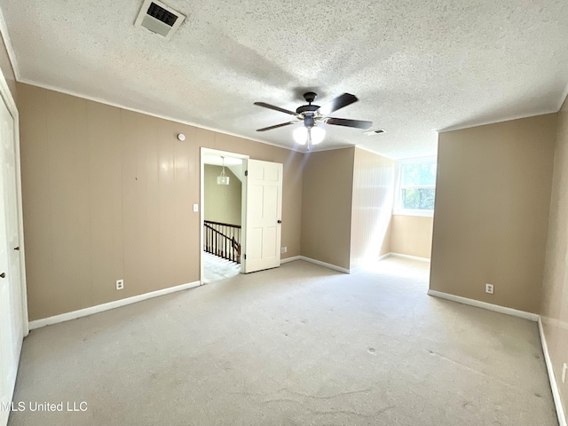 empty room with baseboards, ceiling fan, a textured ceiling, and visible vents