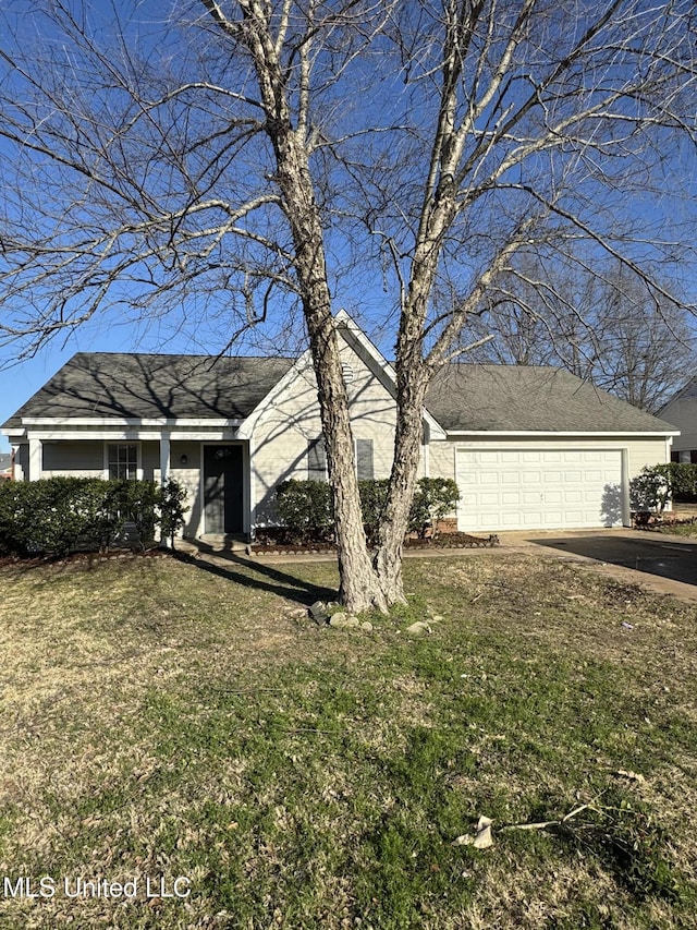 view of front of house with a front lawn, a garage, and driveway