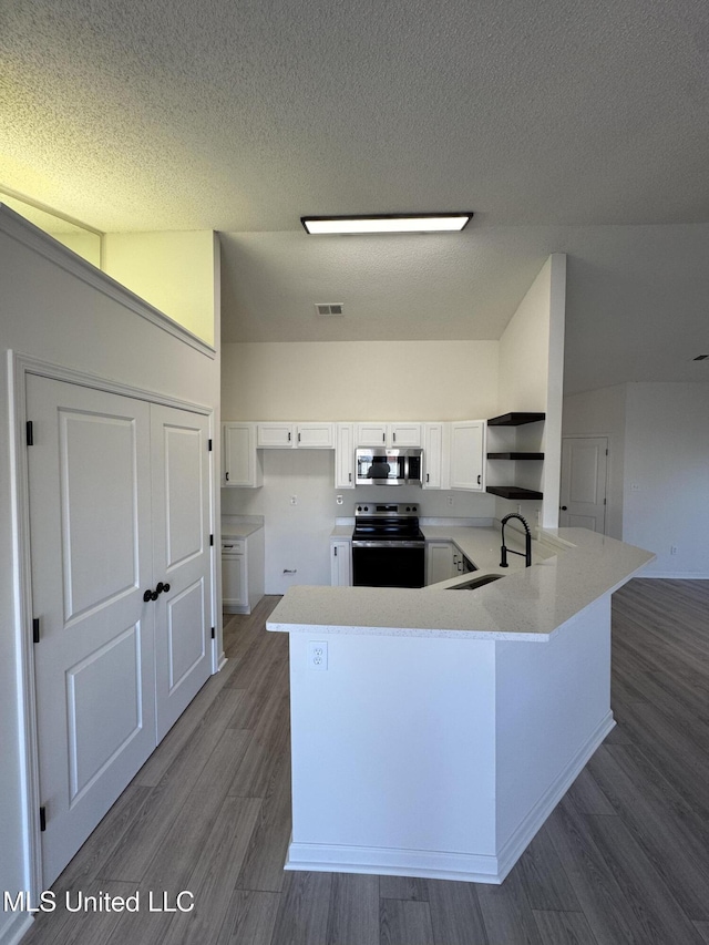 kitchen with visible vents, open shelves, a sink, stainless steel appliances, and white cabinets