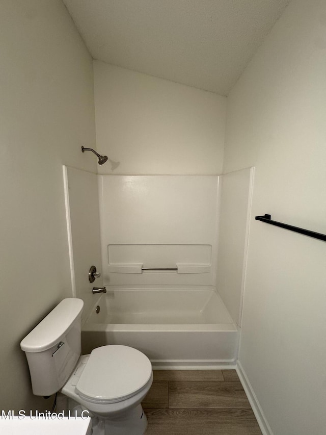 full bathroom featuring tub / shower combination, toilet, and wood finished floors