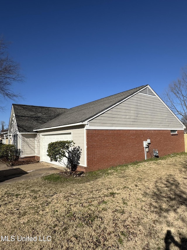 view of property exterior with a garage, brick siding, concrete driveway, and a yard