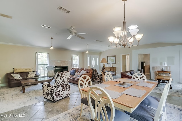 146 Maple Dr, Perkinston, MS 39573 - dining area featuring ceiling fan, vaulted ceiling, ornamental molding, a chandelier, and a tiled fireplace