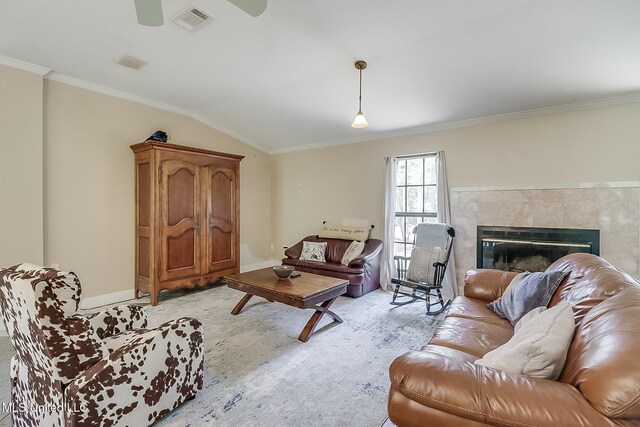 146 Maple Dr, Perkinston, MS 39573 - living room featuring crown molding, a tiled fireplace, baseboards, light wood finished floors, and lofted ceiling
