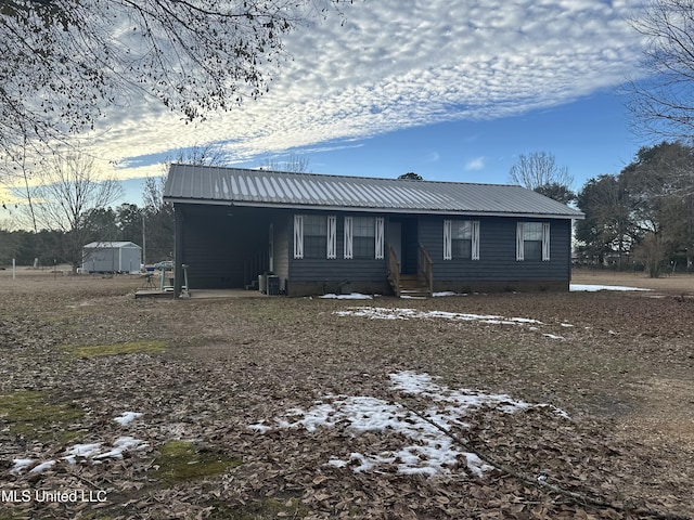 view of front of property with central AC and a shed