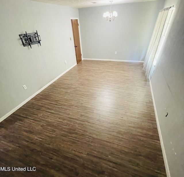 111 Brookfield Dr, Natchez, MS 39120 - spare room featuring a chandelier, dark wood-style flooring, and baseboards