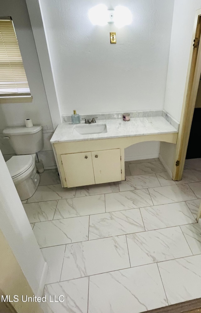 111 Brookfield Dr, Natchez, MS 39120 - bathroom featuring marble look tile flooring, toilet, vanity, and baseboards