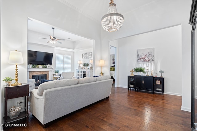 living room featuring crown molding, dark hardwood / wood-style floors, and ceiling fan with notable chandelier