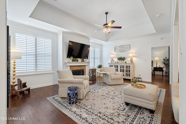 living room with crown molding, ceiling fan, dark hardwood / wood-style flooring, and a tray ceiling