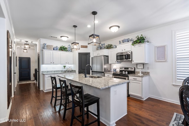 kitchen with stainless steel appliances, white cabinetry, sink, and decorative light fixtures