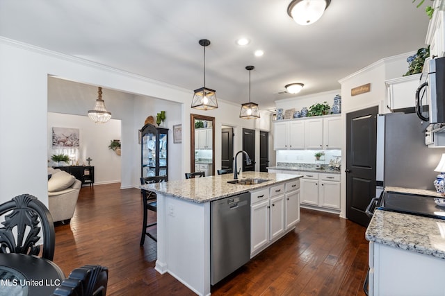 kitchen with sink, stainless steel appliances, an island with sink, white cabinets, and decorative light fixtures