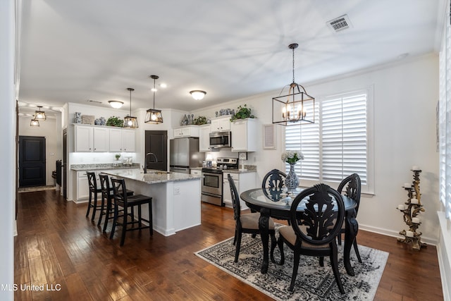 dining area featuring sink, crown molding, dark hardwood / wood-style floors, and a chandelier