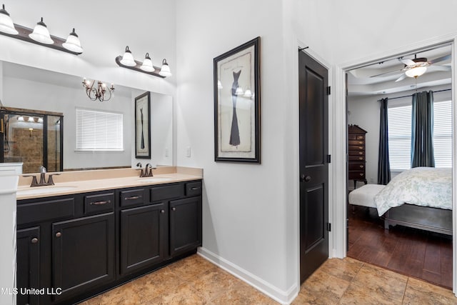 bathroom with vanity, ceiling fan with notable chandelier, and an enclosed shower