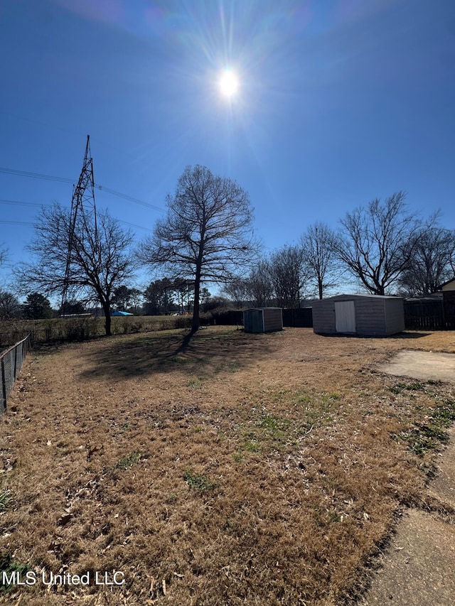 view of yard with fence and an outdoor structure