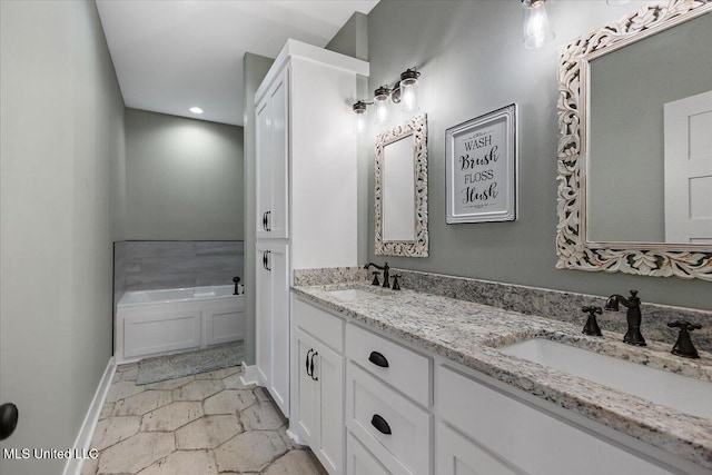 1254 Wade Patrick Rd, Brandon, MS 39042 - bathroom with stone finish floors, a garden tub, baseboards, double vanity, and recessed lighting