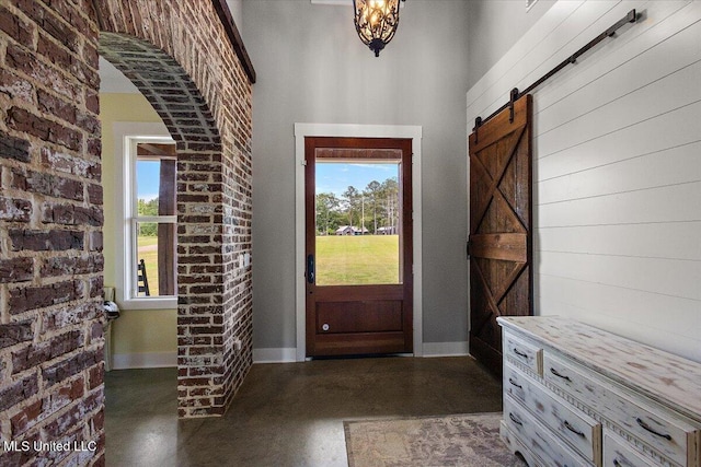 1254 Wade Patrick Rd, Brandon, MS 39042 - entrance foyer featuring concrete floors, a barn door, healthy amount of natural light, and baseboards