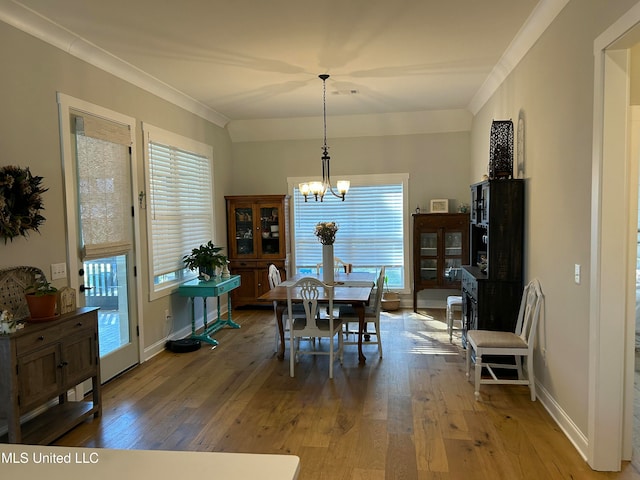 dining room featuring an inviting chandelier, hardwood / wood-style flooring, and ornamental molding