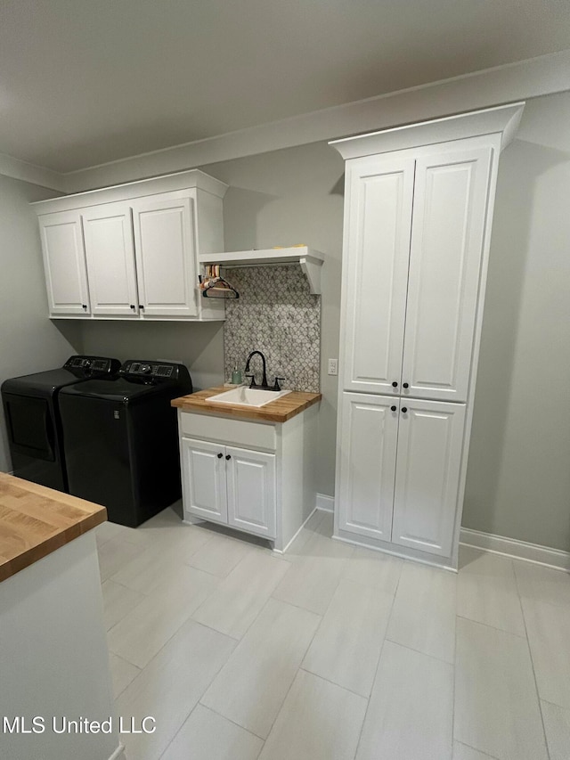 clothes washing area with cabinets, washing machine and dryer, sink, and ornamental molding