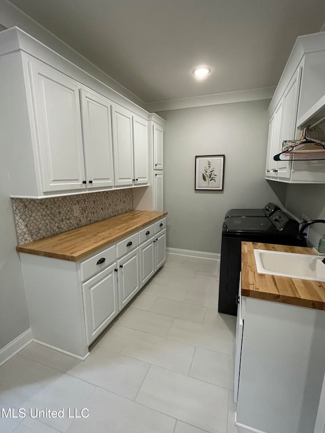 laundry room featuring independent washer and dryer, cabinets, crown molding, and sink