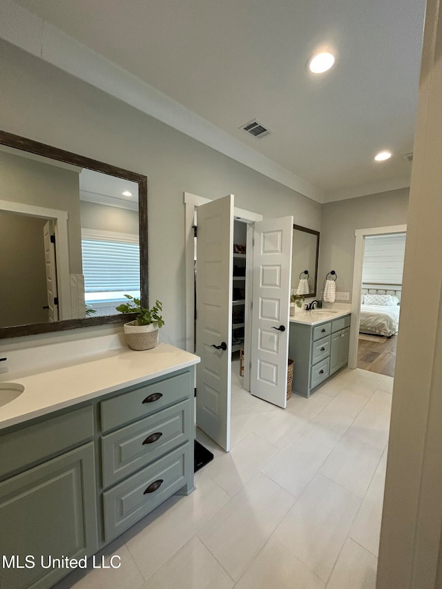 bathroom with tile patterned flooring, vanity, and ornamental molding