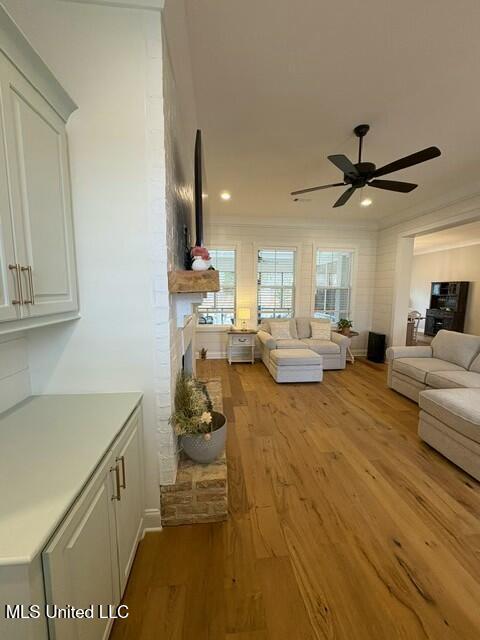 unfurnished living room featuring ceiling fan and light wood-type flooring