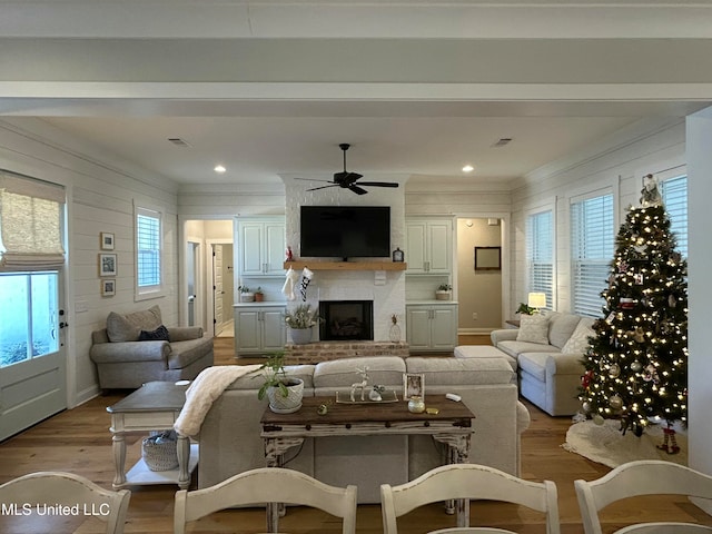 living room with ceiling fan, wood-type flooring, and wood walls