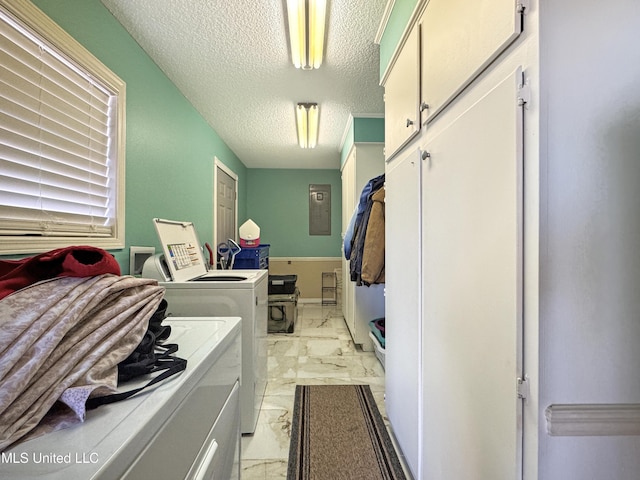 laundry room featuring washer and dryer, a textured ceiling, and cabinets