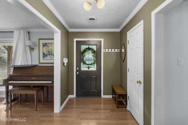 entrance foyer featuring visible vents, ornamental molding, light wood finished floors, and baseboards