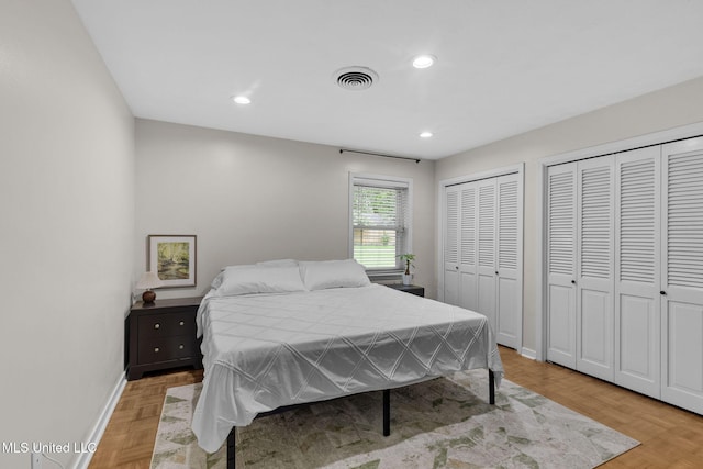 bedroom featuring visible vents, recessed lighting, baseboards, and two closets