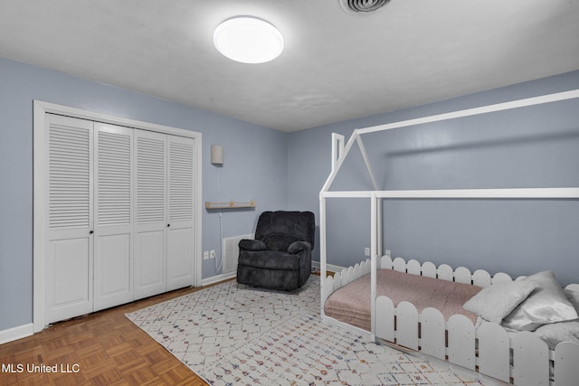 bedroom featuring baseboards, a closet, and visible vents