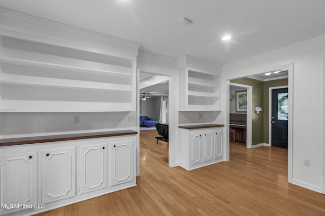 kitchen featuring open shelves, white cabinets, dark countertops, and ornamental molding