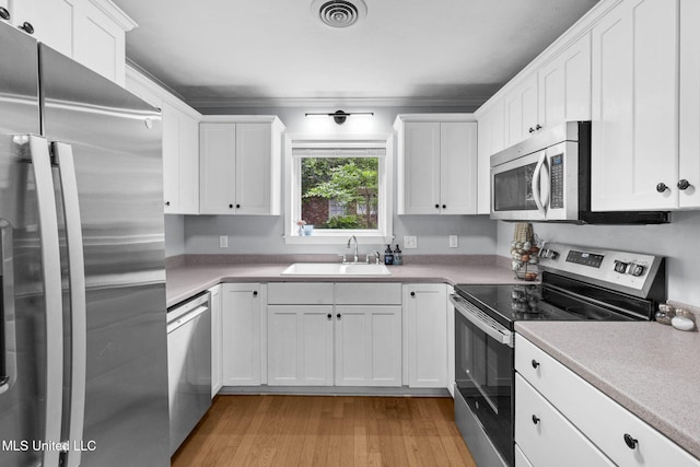 kitchen featuring a sink, white cabinets, stainless steel appliances, and visible vents