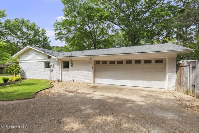 ranch-style home with brick siding, an attached garage, fence, and driveway