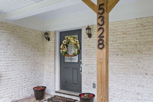 doorway to property with brick siding
